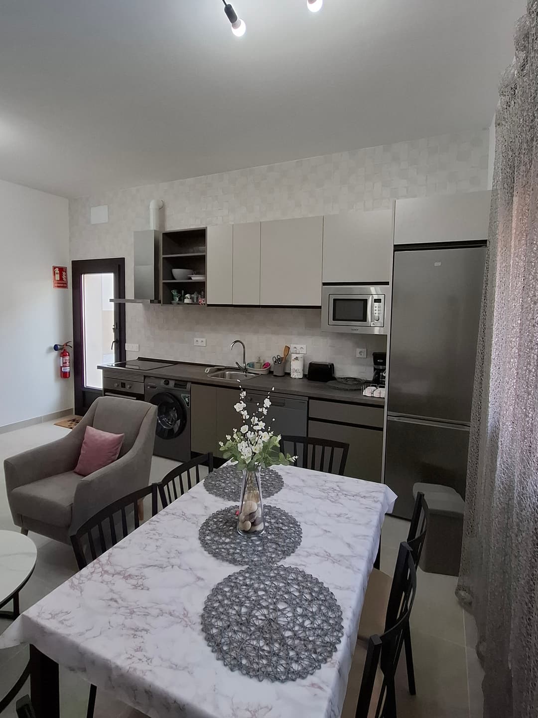 Salón comedor con cocina americana y sofá cama en la casa rural La Jara Rosa. - Imagen 8